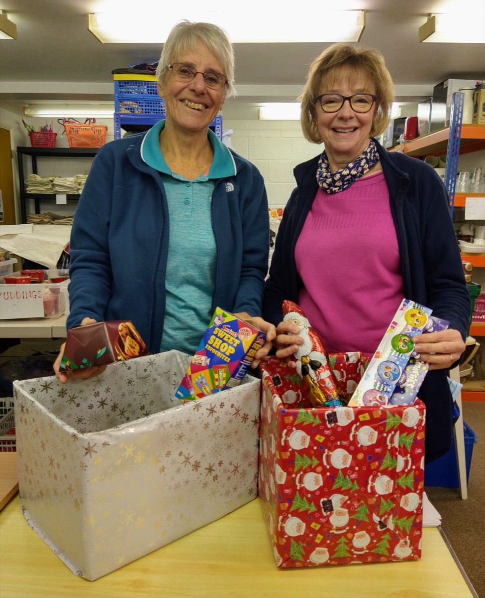 Two volunteers holding boxes of donated food