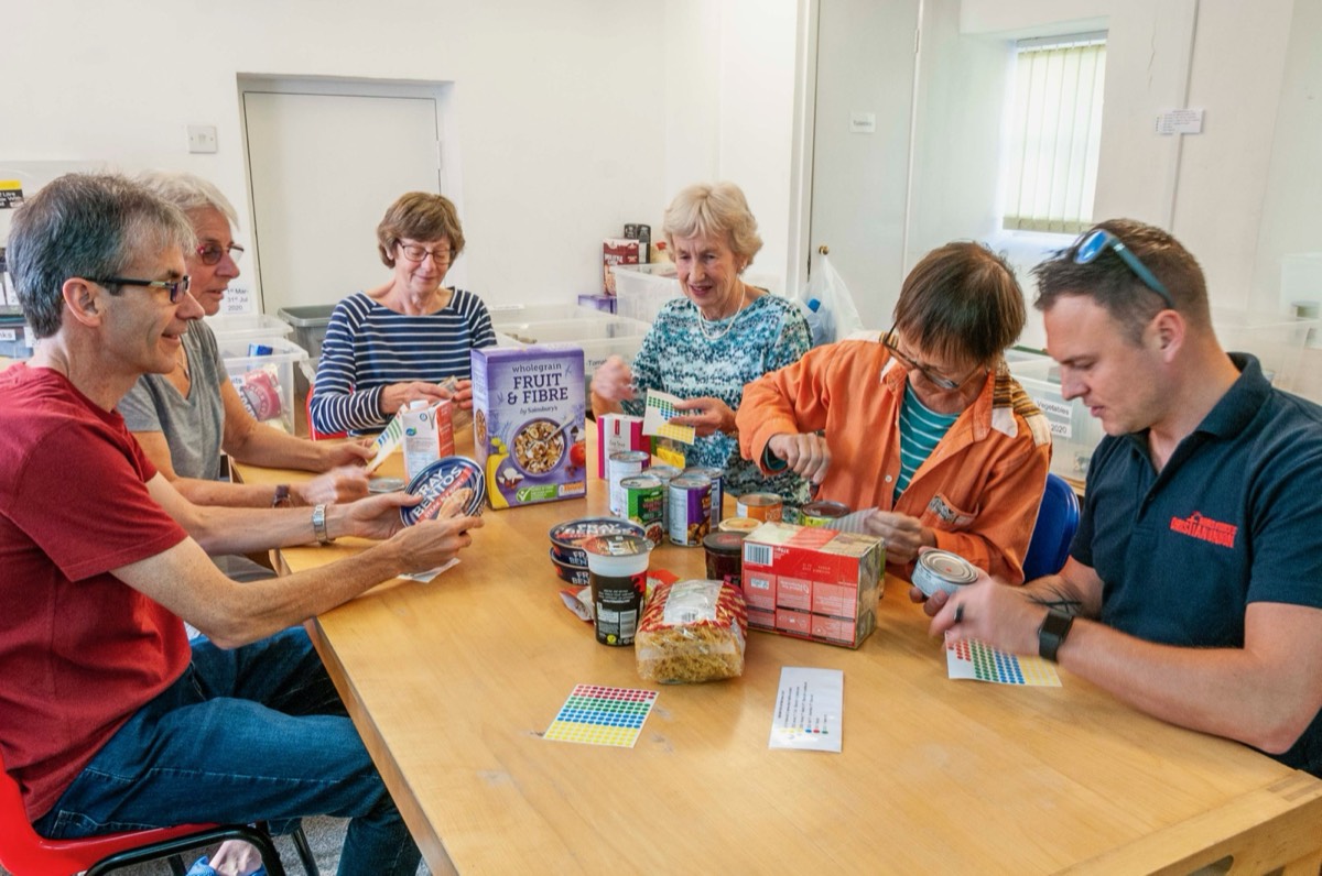 Volunteers around a table sorting donated food